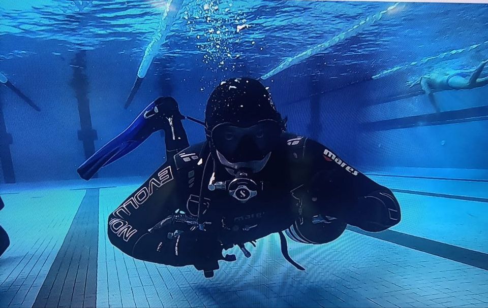 sub fotografato in piscina dalla maschera si intravede lo sguardo che guarda in camera