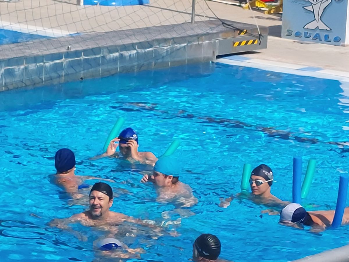 sessione in piscina del corso ripresa più da vicino con vari ragazze e ragazzi e istruttori e istruttrici in acqua