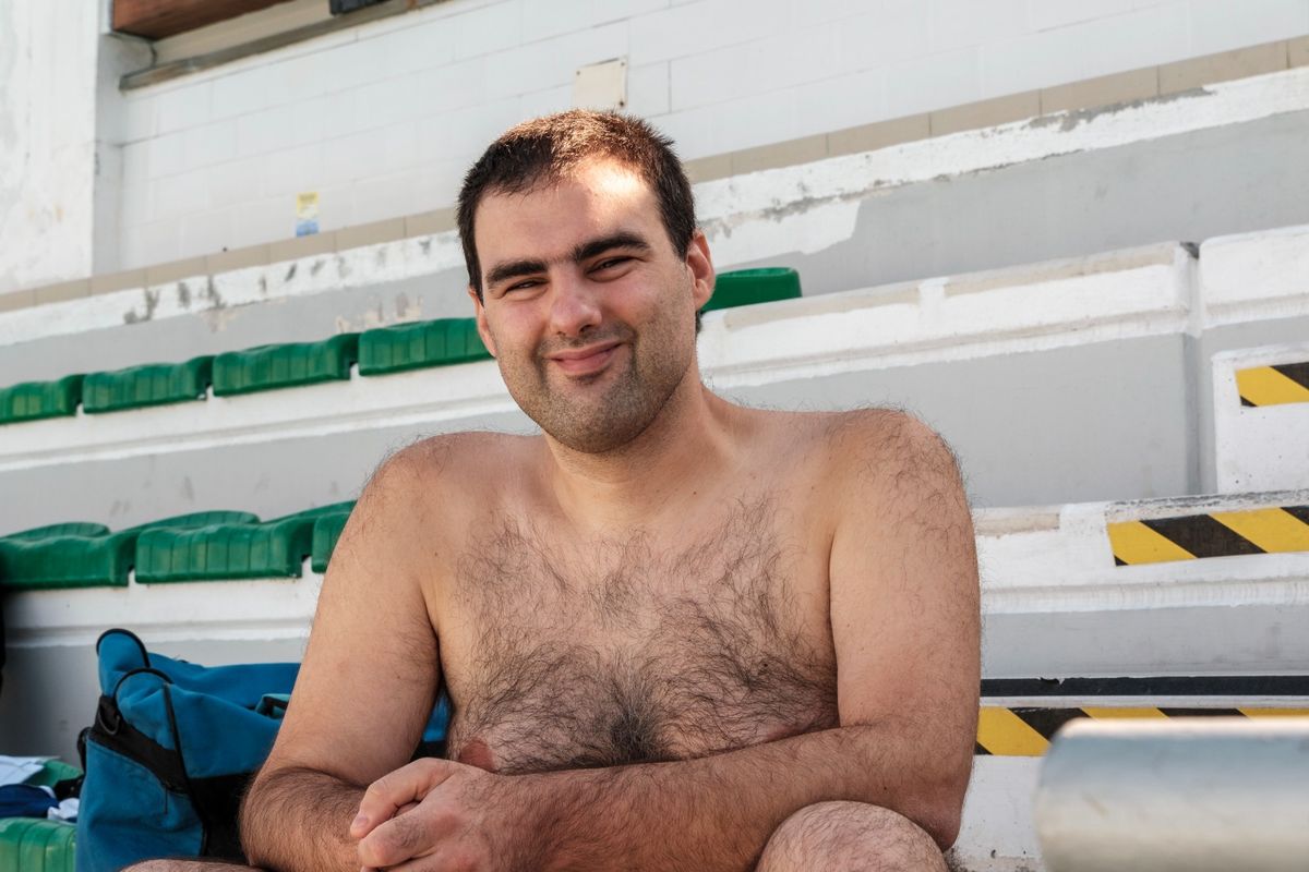 primo piano di un allievo sorridente sugli spalti della piscina prima di entrare in acqua